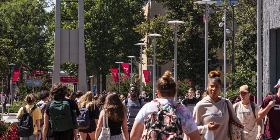 Students walking near the belltower on Main Campus on a sunny spring day